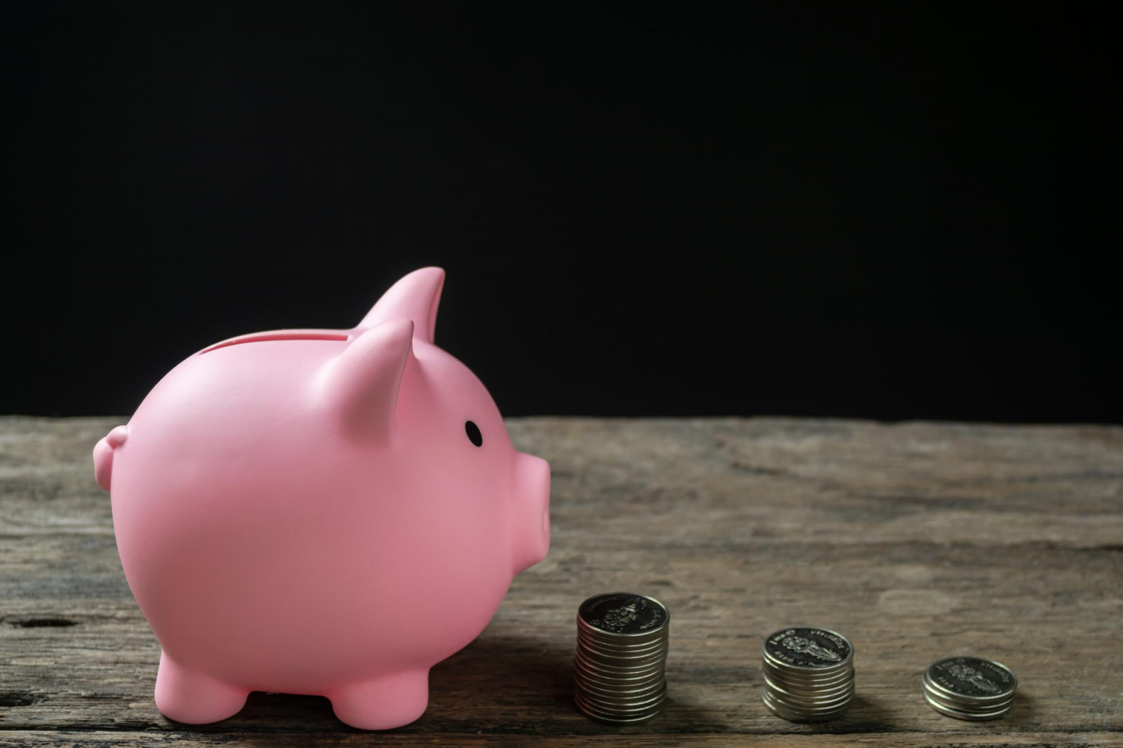 save-money-account-banking-finance-concept-hand-with-coin-piggy-bank-blurred-background.jpg Копилка и монеты на столе