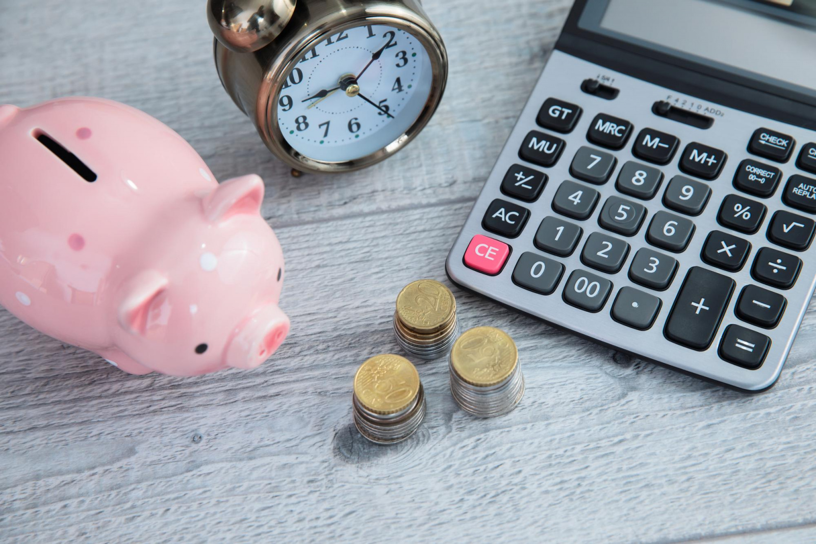coins-with-piggy-bank-calculator.jpg Копилка, калькулятор, часы и монеты на столе